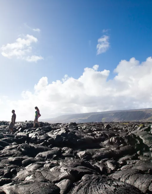 FAQs woman walking along a black lava field