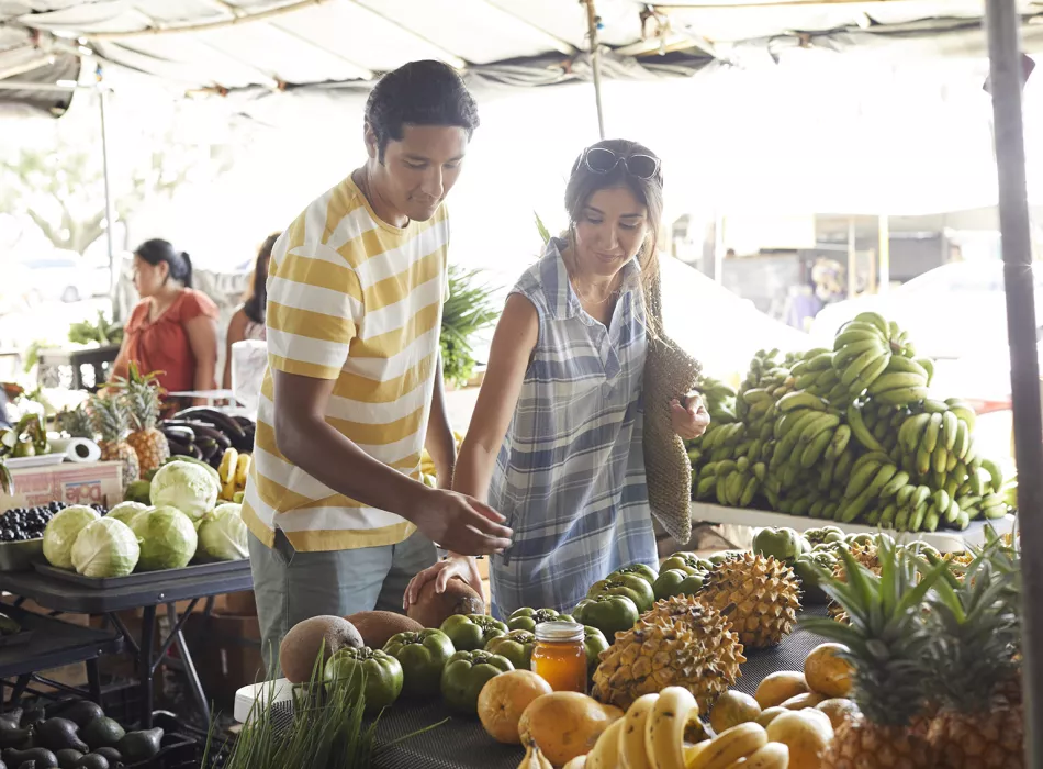 Couple shopping for produce at a farmers market in Hawaii.